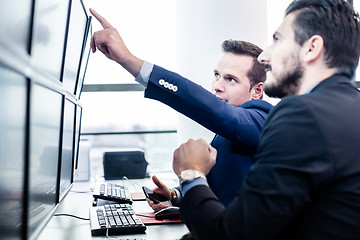 Image showing Stock traders looking at market data on computer screens.