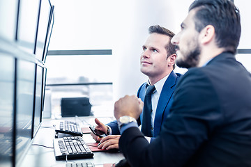 Image showing Stock traders looking at market data on computer screens.