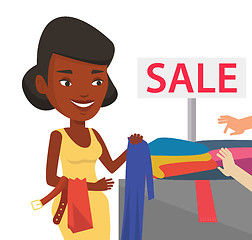 Image showing Young woman choosing clothes in shop on sale.