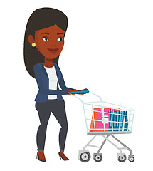 Image showing African woman walking with shopping trolley.