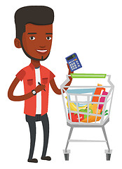 Image showing African man counting prices on calculator.