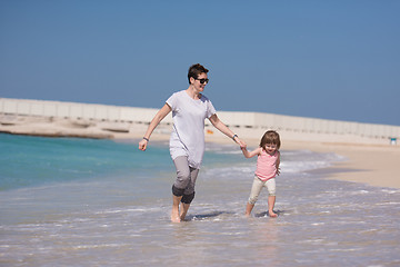 Image showing mother and daughter running on the beach