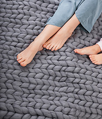 Image showing Mother and daughter legs on woolen knitted plaid