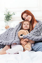 Image showing A little cute girl enjoying, playing and creating with toy with mother