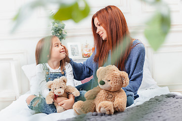 Image showing A little cute girl enjoying, playing and creating with toy with mother