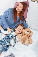 Image showing A little cute girl enjoying, playing and creating with toy with mother