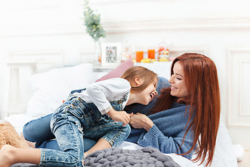 Image showing A little cute girl enjoying, playing and creating with toy with mother