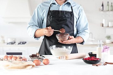 Image showing A cook with eggs on a rustic kitchen against the background of men\'s hands