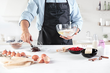 Image showing A cook with eggs on a rustic kitchen against the background of men\'s hands