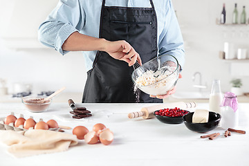 Image showing A cook with eggs on a rustic kitchen against the background of men\'s hands