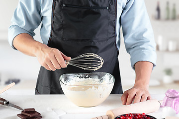 Image showing A cook with eggs on a rustic kitchen against the background of men\'s hands