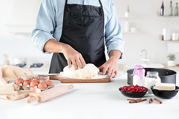 Image showing A cook with eggs on a rustic kitchen against the background of men\'s hands