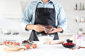 Image showing A cook with eggs on a rustic kitchen against the background of men\'s hands