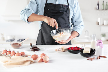 Image showing A cook with eggs on a rustic kitchen against the background of men\'s hands