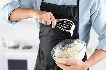 Image showing A cook with eggs on a rustic kitchen against the background of men\'s hands