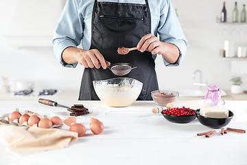 Image showing A cook with eggs on a rustic kitchen against the background of men\'s hands