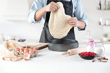 Image showing A cook with eggs on a rustic kitchen against the background of men\'s hands