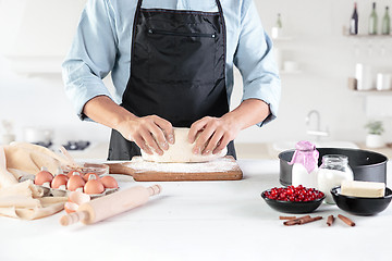 Image showing A cook with eggs on a rustic kitchen against the background of men\'s hands