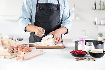 Image showing A cook with eggs on a rustic kitchen against the background of men\'s hands