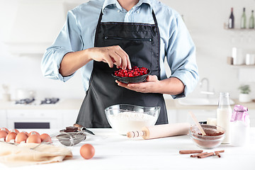 Image showing A cook with eggs on a rustic kitchen against the background of men\'s hands