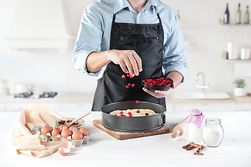 Image showing A cook with eggs on a rustic kitchen against the background of men\'s hands