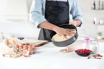 Image showing A cook with eggs on a rustic kitchen against the background of men\'s hands