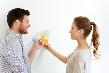 Image showing happy couple with color samples at new home
