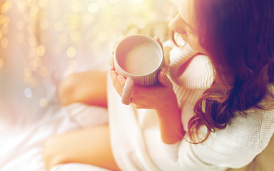 Image showing close up of woman with cocoa cup in bed at home