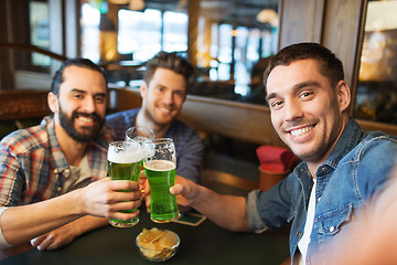 Image showing friends with green beer taking selfie at pub