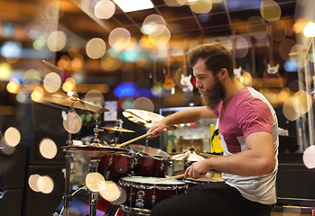 Image showing male musician playing cymbals at music store