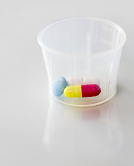 Image showing close up of pills and capsule in medicine cup