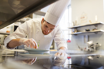 Image showing happy male chef cooking food at restaurant kitchen