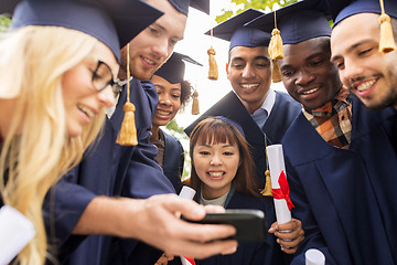 Image showing students or graduates with diplomas and smartphone