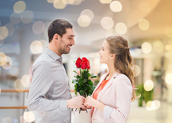 Image showing happy young couple with flowers in mall