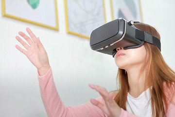 Image showing Young woman wearing virtual reality glasses at home.