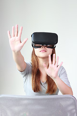 Image showing Young woman wearing virtual reality glasses at home.