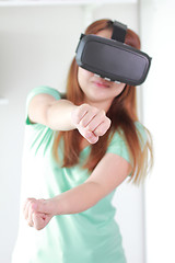 Image showing Young woman wearing virtual reality glasses at home.