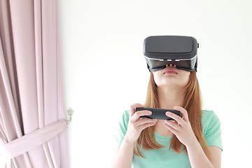 Image showing Young woman wearing virtual reality glasses at home.