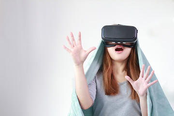 Image showing Young woman wearing virtual reality glasses at home.