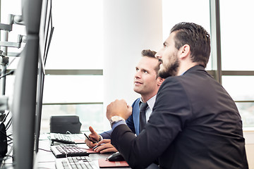 Image showing Stock traders looking at market data on computer screens.