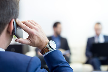 Image showing Corporate business team at business meeting and manager talking on phone.