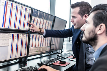 Image showing Stock traders looking at market data on computer screens.