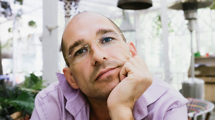 Image showing Pensive Man Wearing Glasses Sitting On A Summer Terrace