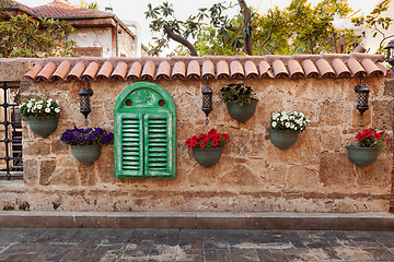 Image showing Old stonewall decorated with flowers