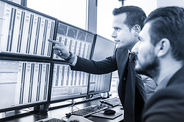 Image showing Stock traders looking at market data on computer screens.