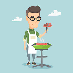 Image showing Man cooking steak on barbecue grill.