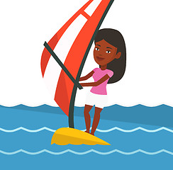 Image showing Young woman windsurfing in the sea.