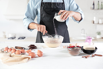 Image showing A cook with eggs on a rustic kitchen against the background of men\'s hands