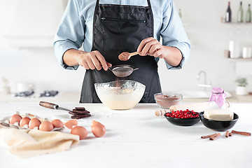 Image showing A cook with eggs on a rustic kitchen against the background of men\'s hands