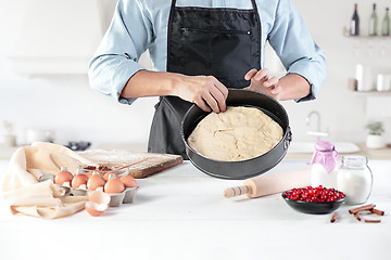 Image showing A cook with eggs on a rustic kitchen against the background of men\'s hands